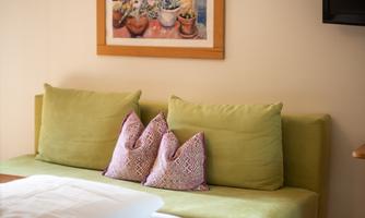 A cozy room with a sofa and cushions.