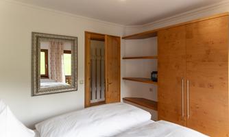 The Hochwurzen apartment has two separate bedrooms. This one additionally has direct access to the balcony. From there, you have a beautiful view of the surrounding mountains and the green nature.