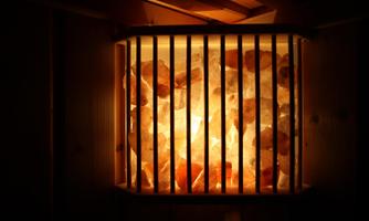 An illuminated salt stone inside a sauna. The gentle lighting creates a relaxing atmosphere.