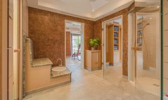 A modern bathroom with elegant walls and a shower. There is a cozy seating area and plants for a pleasant ambiance.
