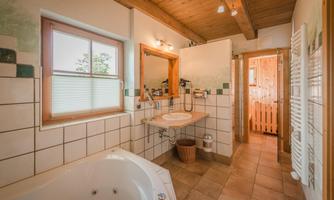 A modern bathroom with a bathtub and a sink. Bright tiles and wooden details create a pleasant atmosphere.
