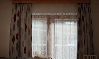 A window with curtains in modern patterns. The influx of daylight creates a bright and welcoming atmosphere.