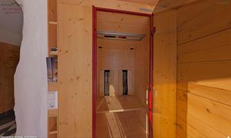 A modern elevator with wooden paneling and minimalist design. The walls are light and the lighting creates a friendly atmosphere.