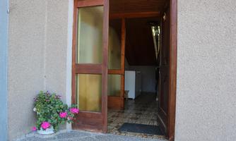An inviting entrance area with a wooden door and a colorful flower planter. The interior is bright and friendly designed.