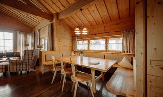 A cozy dining area with wood decor and natural light. The room is designed to be warm and inviting.