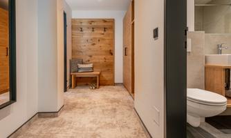 A modern bathroom with an elegant sink and a heated towel rail. The room has warm wood accents and a cozy atmosphere.