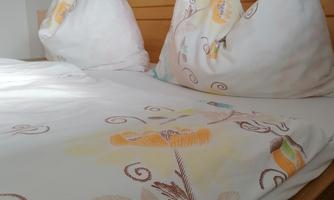 A cozy bed with pretty bedding and decorative pillows. The colors and patterns create an inviting impression.