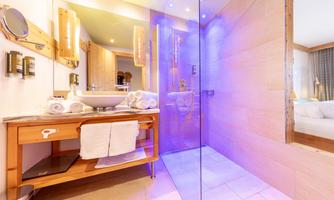 A modern bathroom with a glass shower and stylish wooden cabinet. The soft lighting creates a relaxing atmosphere.
