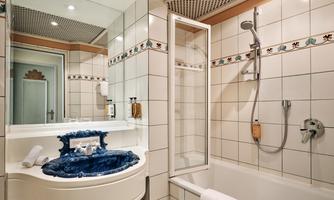 A bathroom with a bathtub. The sink is designed in a striking blue design.