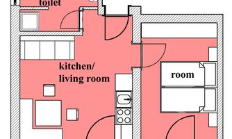A floor plan of an apartment. It shows a bathroom, a kitchen with a living area, and two rooms.