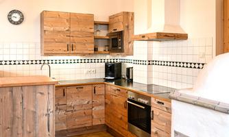A modern wooden kitchen with style. The space features elegant cabinets, a stove, and a bright environment.