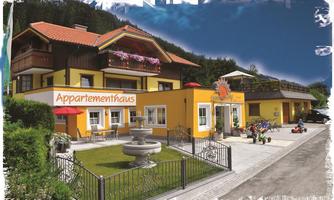 A cozy apartment house with a colorful facade. In front of the building, there is a beautiful fountain and a play area for children.