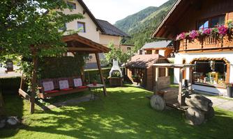 A beautiful garden with a cozy seating area and a view of the mountains. The surroundings are inviting and typical of alpine architecture.