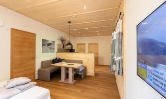 A modern room with wooden walls and a cozy dining area. The decor is stylish and inviting.
