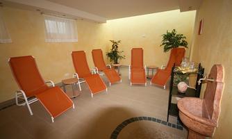 A relaxing rest room with orange loungers and some plants. The walls are painted in warm colors, creating a calming atmosphere.