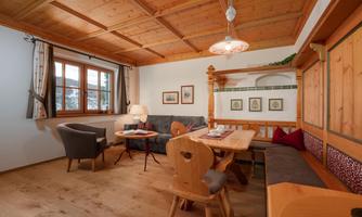 A cozy room with wooden furniture and a large table.  
Large windows provide plenty of daylight and an inviting atmosphere.