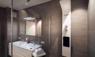 A modern bathroom with an elegant shower and double sink. The walls are painted in neutral gray tones, and fresh towels are laid out.