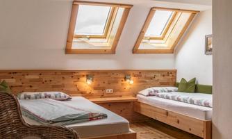 A cozy bedroom with skylights and two beds.  
Wood details and natural materials create an inviting atmosphere.