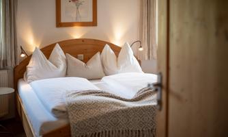 A cozy bedroom with a double bed and stylish pillows. Soft light and an inviting atmosphere create relaxation.