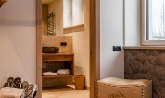 A modern bathroom with wooden details and a large window. The environment is bright and inviting, with a warm color palette.