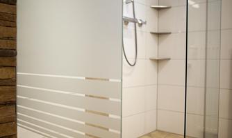 A modern shower with a glass partition and elegant tiles. The shower is bright and invites relaxation.