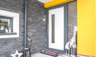 A modern front door in an appealing environment. The entryway is open and decorated with a stylish star and figures.