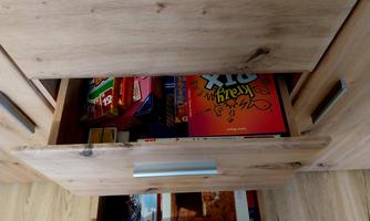 An open drawer with various board games and snacks. The contents of the drawer are colorful and neatly stacked.