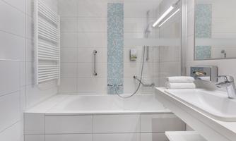 A modern bathroom with a bathtub and a large shower. Bright tiles and a functional design create a pleasant atmosphere.