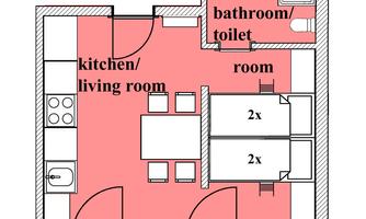 A floor plan drawing of an apartment with a kitchen/living room, a bathroom, and two bedrooms. The rooms are clearly structured and organized.
