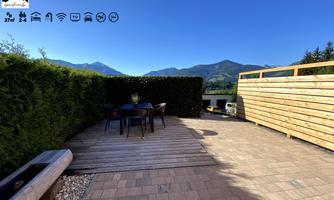 A cozy terrace with a view of the mountains. Tables and chairs invite you to relax.