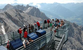 A viewpoint in the mountains full of tourists. In the background, majestic mountain panoramas can be seen.