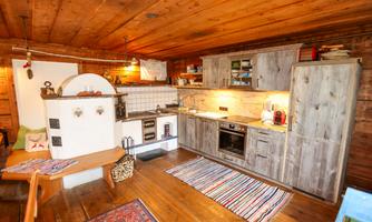A cozy kitchen with wooden paneling and modern appliances. The room is lovingly decorated and radiates warmth and coziness.