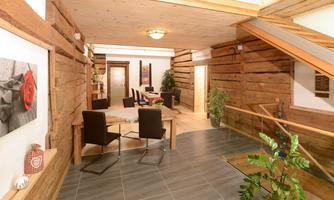 An inviting entrance area with wood paneling and modern furniture. The warm colors and plants create a cozy atmosphere.