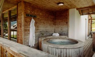 A cozy wellness area with a wooden bath and rustic furnishings. Soft towels and a relaxing atmosphere invite you to linger.