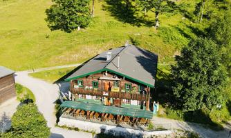 A charming old building in a green landscape. The surroundings are surrounded by trees and meadows.