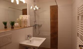 A modern bathroom with a walk-in shower and a sink. Clean lines and subtle decoration create an inviting atmosphere.