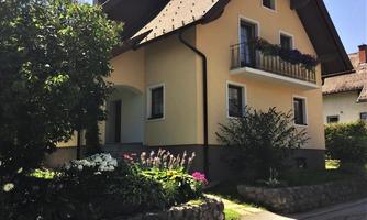 A charming house with a yellow facade and a planted front garden. The surroundings are green and friendly, ideal for a peaceful living atmosphere.