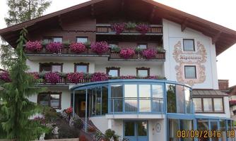 A charming building with balconies full of blooming plants. The facade is traditionally and invitingly designed.
