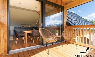 A modern balcony with two chairs and a view of nature. The space exudes brightness and coziness.
