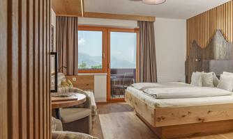 A modern room with wooden decor and large windows. The view of the mountains provides a relaxed atmosphere.