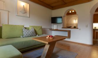 The Planai apartment has a cozy living room, equipped with a television and a view of the kitchen.
