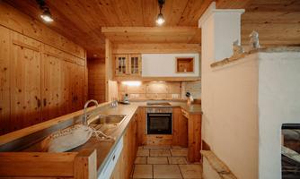 A cozy kitchen with wooden paneling and modern appliances. The warm colors create an inviting atmosphere.