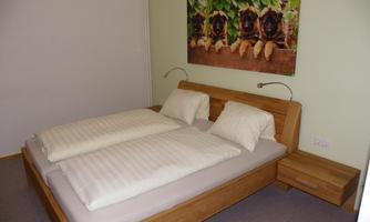 A cozy bedroom with a double bed and two pillows. On the wall, there is a decorative picture of animals.