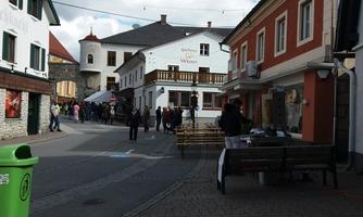 A picturesque street with historic buildings and people walking around. The sky is partly cloudy and offers a lovely view of the surroundings.