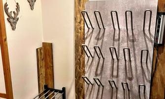 An entrance area with wooden details and a warm "Welcome" mat. Deer antlers and a decorative wreath hang on the wall.