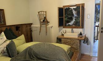 With a double bed made of reclaimed wood, a sink, and a terrace.