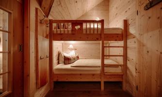 A cozy bedroom with a wooden bunk bed. The walls are in warm wood tones, creating an inviting atmosphere.