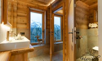A modern bathroom with wooden walls and large windows that offer a view of the mountains. The furnishings are stylish and cozy.