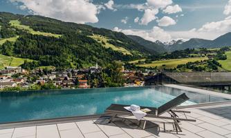 A beautiful view of the mountains and the city from an infinity pool. Relaxed loungers invite you to linger.