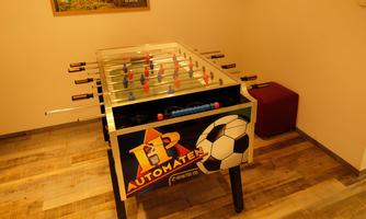 A foosball table is in a room. The table has a colorful design and is ready for a game.